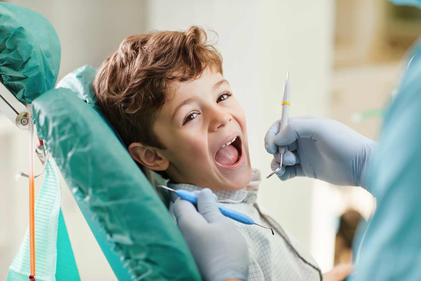 Child Smiling While Sitting in the Dentist's Chair.